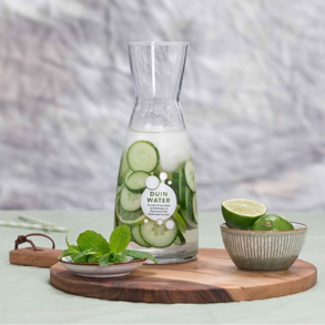 Mocktail met munt, limoen en komkommer in een karaf en glas